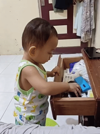 Toddler rummages through drawer and plays with nail clipper