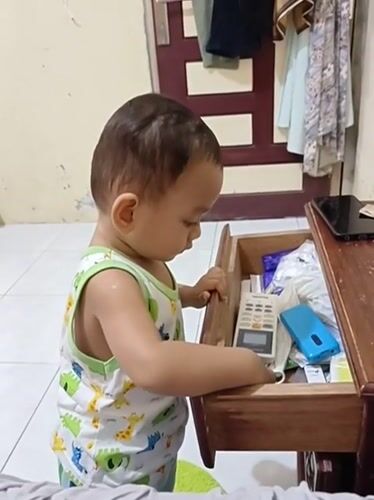Toddler rummages through drawer and plays with nail clipper