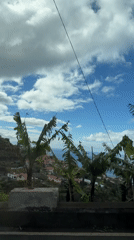 Coastal village with red roofs filmed from elevated Ponta do Sol road