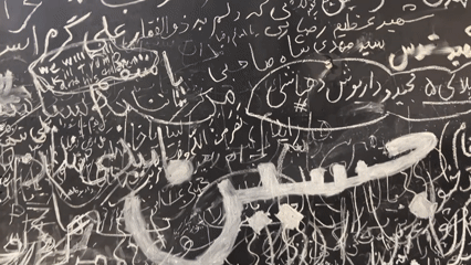 Chalk-covered wall in Tehran draws people writing and paying tribute