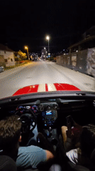 Group drives red convertible through Bar, Montenegro at night