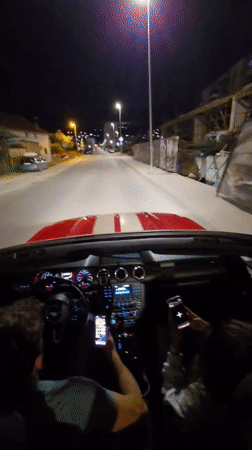 Group drives red convertible through Bar, Montenegro at night