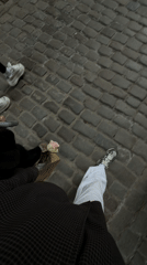 Two people stroll cobblestone street in Gdańsk