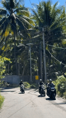 Three motorcyclists travel road in Apitaik, Indonesia