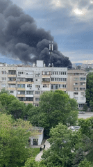 Black smoke plume observed behind apartment building