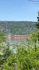 Tugboat tows barge across river near Yonkers cliffs