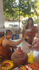Buddhist monk blesses family at Thai temple ceremony