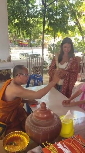 Buddhist monk blesses family at Thai temple ceremony