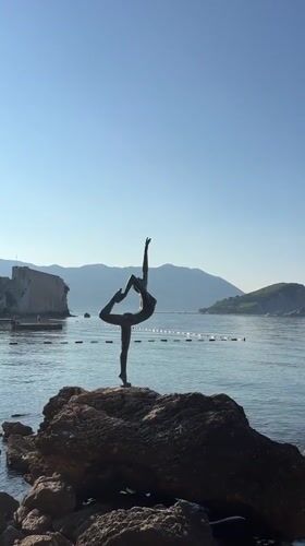 Touching the dancer statue on Budva's rocky coastline