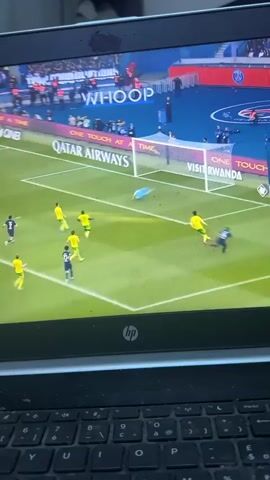The video displays an HP laptop screen showing a live football match. The score, "PSG 1 NANT 0," is visible in the top left corner, indicating a game between Paris Saint-Germain and Nantes. The scene captures a moment immediately after a goal, with a player in a blue jersey celebrating with his arms raised, while other players in yellow and blue jerseys are on the field. A goalkeeper in a light blue kit is near the goal.

The football pitch is green, surrounded by advertising boards displaying texts such as "QATAR AIRWAYS" and "VISIT RWANDA." Other words like "WHOOP" and "TIEMPO" are also visible on the screen. Blurred spectators fill the stadium stands in the background. The laptop's black keyboard is in the foreground, with the "hp" logo visible on the screen's lower bezel. The overall impression is of a thrilling sports moment being watched on a personal device.