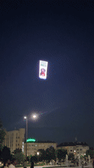 Aerial view of a glowing digital billboard over Sofia at night