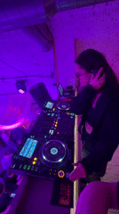 Woman DJs at purple-lit club party in Krasnoyarsk