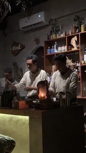 Bartenders craft cocktails at candlelit Ubud establishment