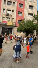 Brass band and circle dancing in a sunny Barcelona plaza