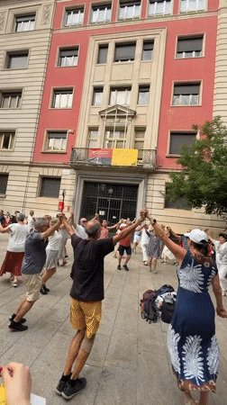 Brass band and circle dancing in a sunny Barcelona plaza
