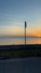 Dawn drive captured along waterfront road in Chaikovsky, Russia