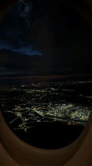 Nighttime aerial view captured over illuminated Schwechat from airplane
