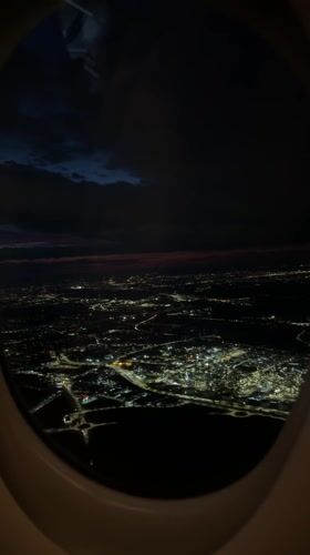 Nighttime aerial view captured over illuminated Schwechat from airplane