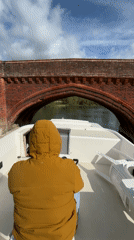 Boater navigates under historic bridge in Clifton Hampden