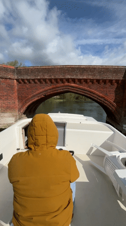 Boater navigates under historic bridge in Clifton Hampden