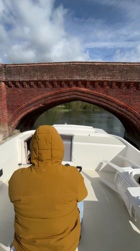 Boater navigates under historic bridge in Clifton Hampden