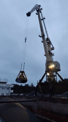 Nighttime crane operations unload gravel at Shalsky port facility