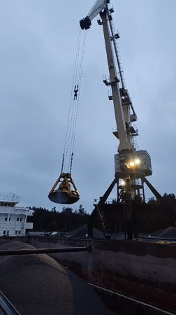 Nighttime crane operations unload gravel at Shalsky port facility
