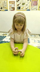 Child plays with objects at green table in Podgorica classroom