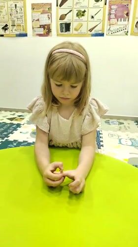 Child plays with objects at green table in Podgorica classroom
