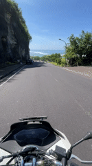 Motorcycles navigate cliff road in Kuta Selatan, Indonesia
