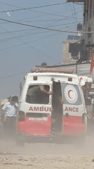 Red Crescent ambulance moves through Gaza dirt road