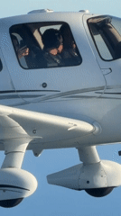 Close-up cockpit view of a white airplane in flight near Carpinteria