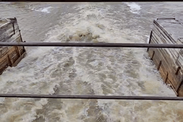 Turbulent Waters Flow Through Dam Structure With Wooden Platforms