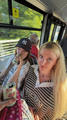 Two women drink from cans on Belgrade bus