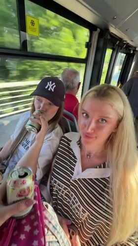 Two women drink from cans on Belgrade bus