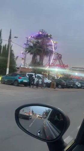 Evening drive past illuminated amusement park in Morocco