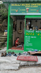 Local businesses and mountain road documented in Bhagsu, India