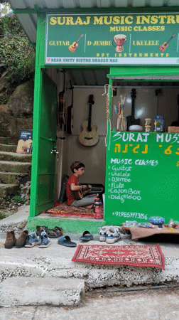 Local businesses and mountain road documented in Bhagsu, India