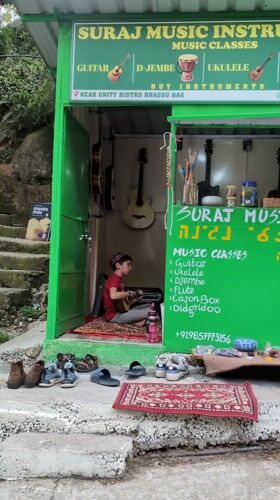 Local businesses and mountain road documented in Bhagsu, India