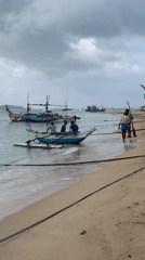 Fishing boats and gear along Mirissa's cloudy shoreline