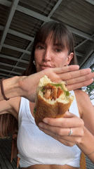 Woman eats large sandwich in North Kuta, Indonesia