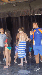 Poolside gathering features presenter and dancing families in Porlamar