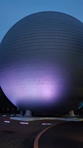 Jeju Science Center glows at dusk alongside a robot barista