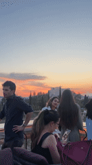 Athens rooftop gathering enjoys sunset view near Acropolis