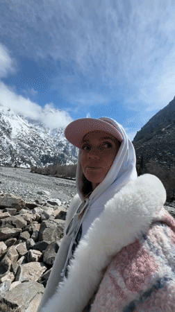 Woman explores mountain river valley in Kyrgyzstan spring morning