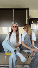 Two women dance and socialize indoors in Belgrade suburb