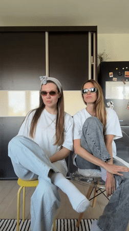 Two women dance and socialize indoors in Belgrade suburb