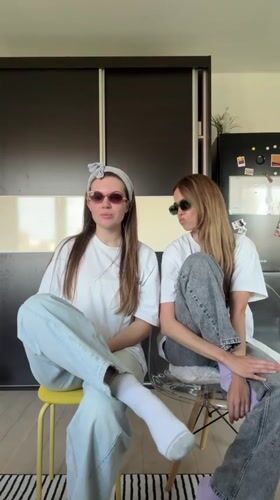 Two women dance and socialize indoors in Belgrade suburb