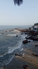 Ocean waves crash against rocks at Querim beach