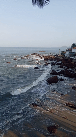 Ocean waves crash against rocks at Querim beach
